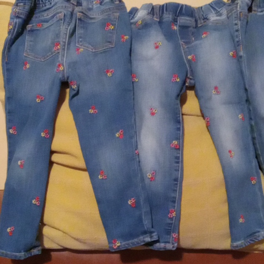 Childrens Gap blue denim jeggings with pink, yellow and red floral embroidery.